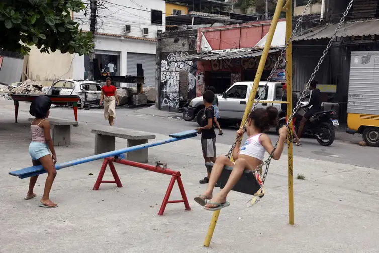 Tânia Rêgo/Agência Brasil Rio de Janeiro (RJ), 30/10/2025 – Crianças brincam em praça da Vila Cruzeiro ao lado de barricadas que foram colocadas para conter avanço de policiais durante a Operação Contenção. Foto: Tânia Rêgo/Agência Brasil